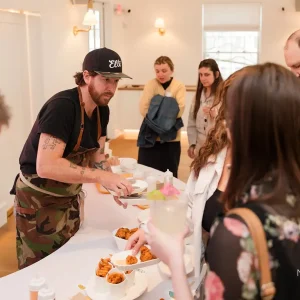 Caterer serving food at a stylish event in Belvedere Lenox, with guests engaging and enjoying the luxurious atmosphere of the venue.