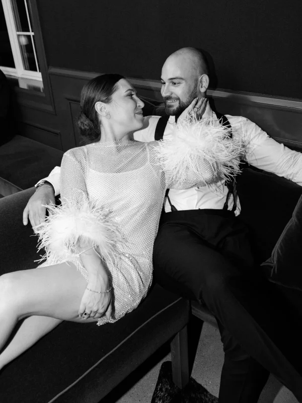 Couple in elegant attire sharing an intimate moment on a sofa, showcasing a stylish wedding or event atmosphere at Belvedere Lenox.